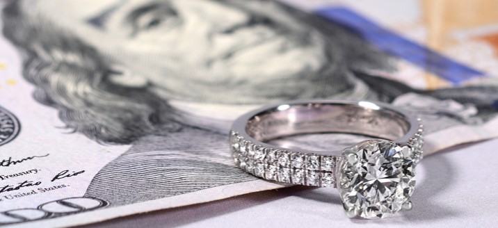 engagement ring sitting on some cash