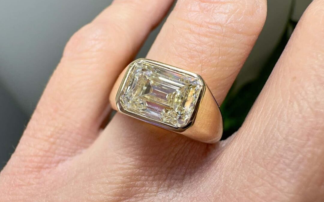 Chunky yellow diamond engagement ring with emerald cut in a thick gold bezel setting