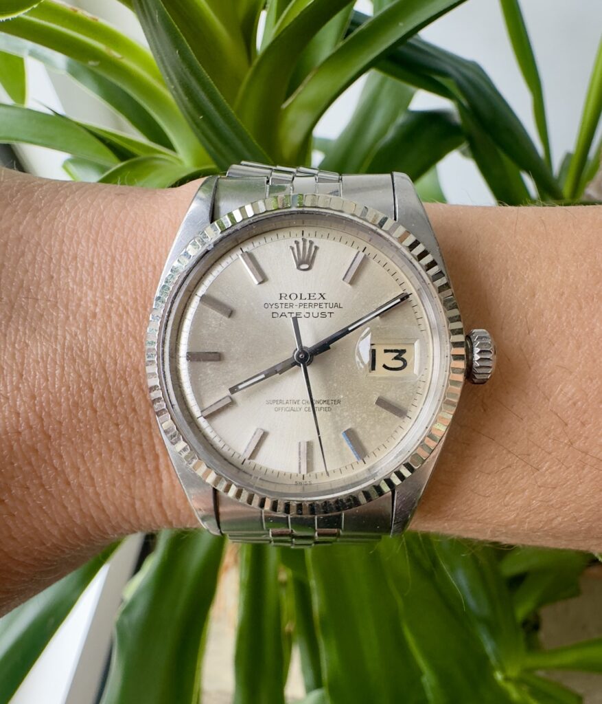 Rolex Datejust stainless steel watch on wrist with fluted bezel and silver dial